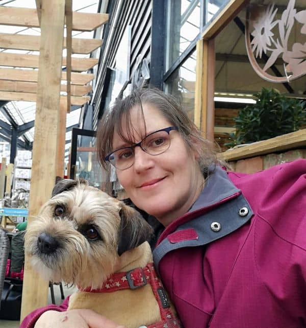Sarah and a small dog sitting in a cafe.